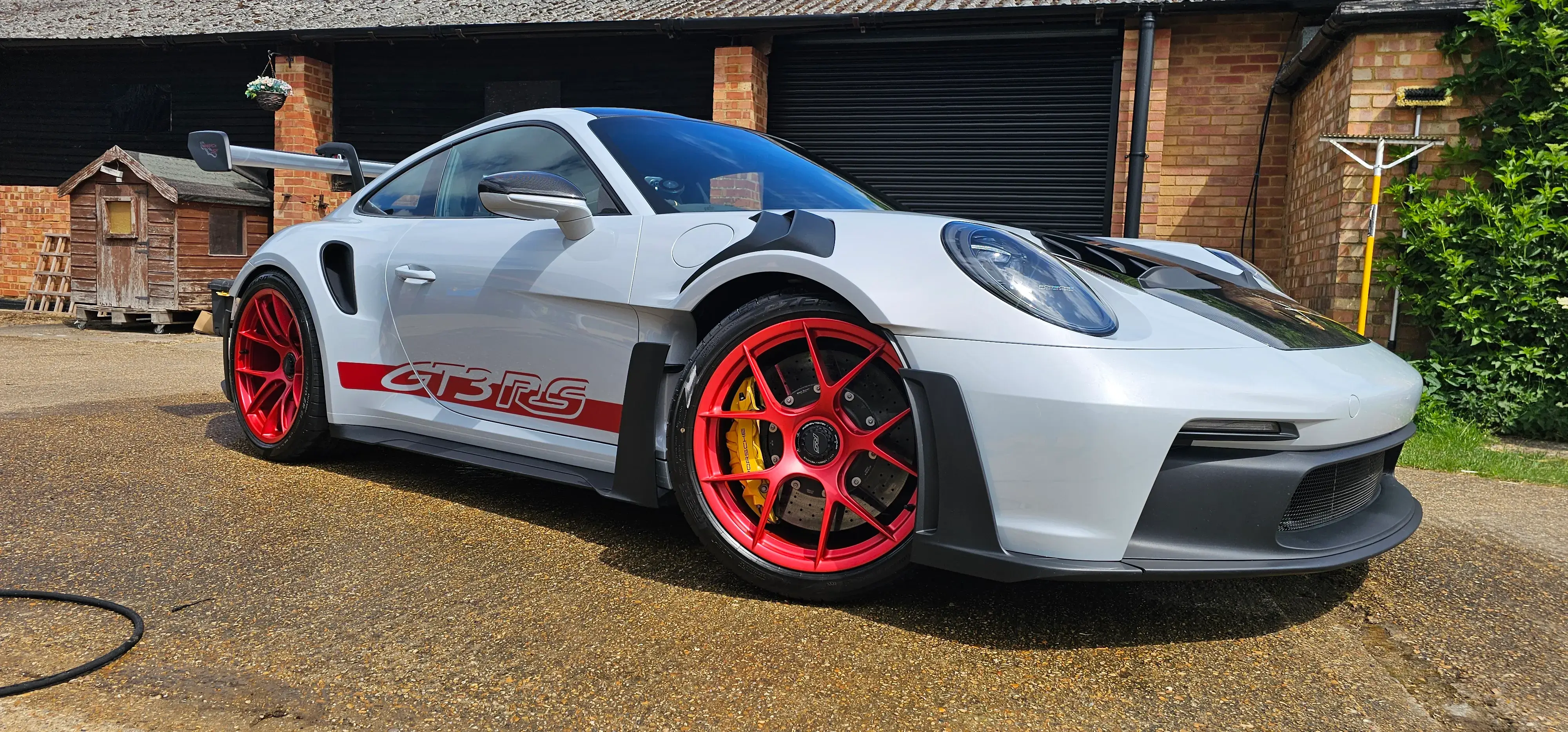 A white and red sports car parked in front of a garage.