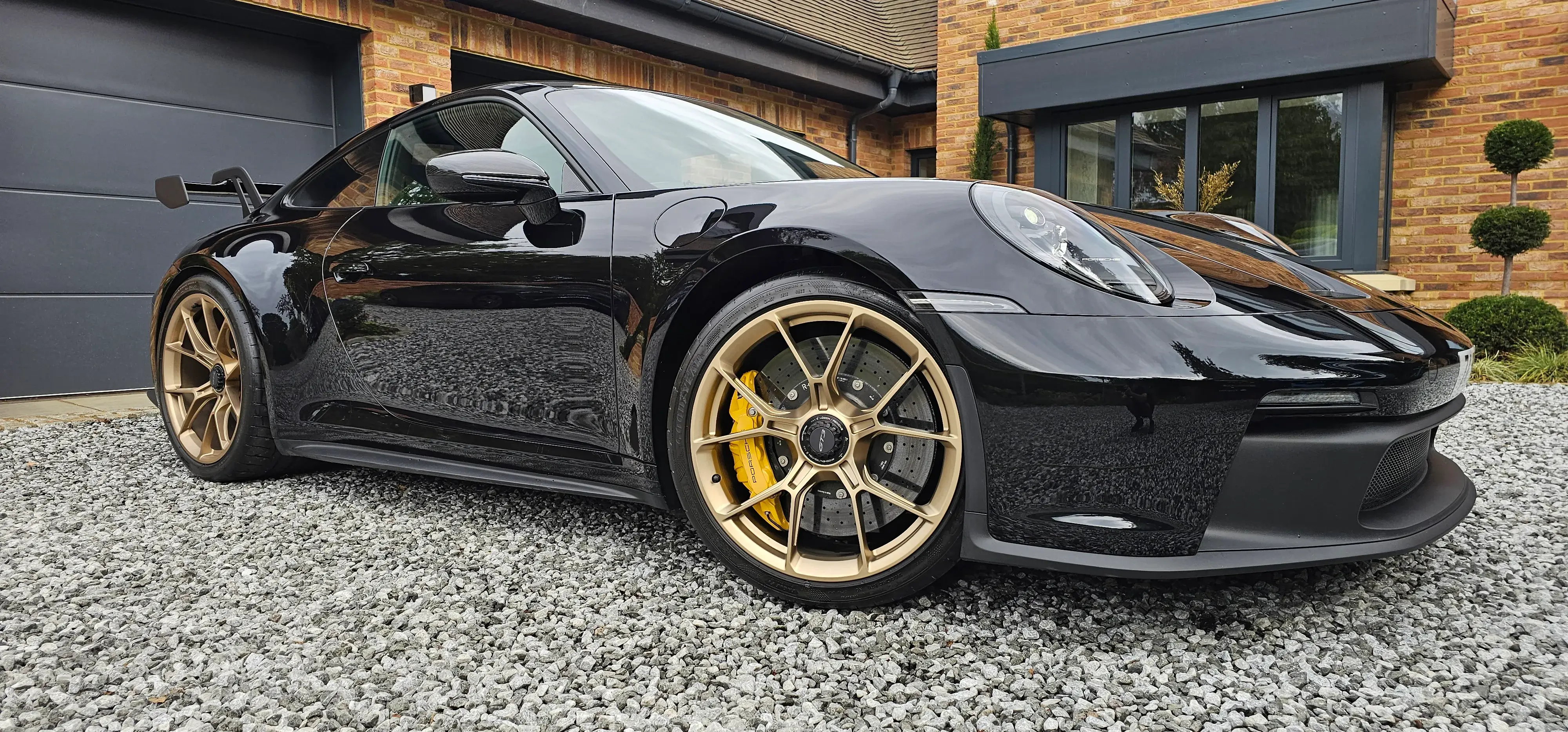 A black sports car parked in front of a house.
