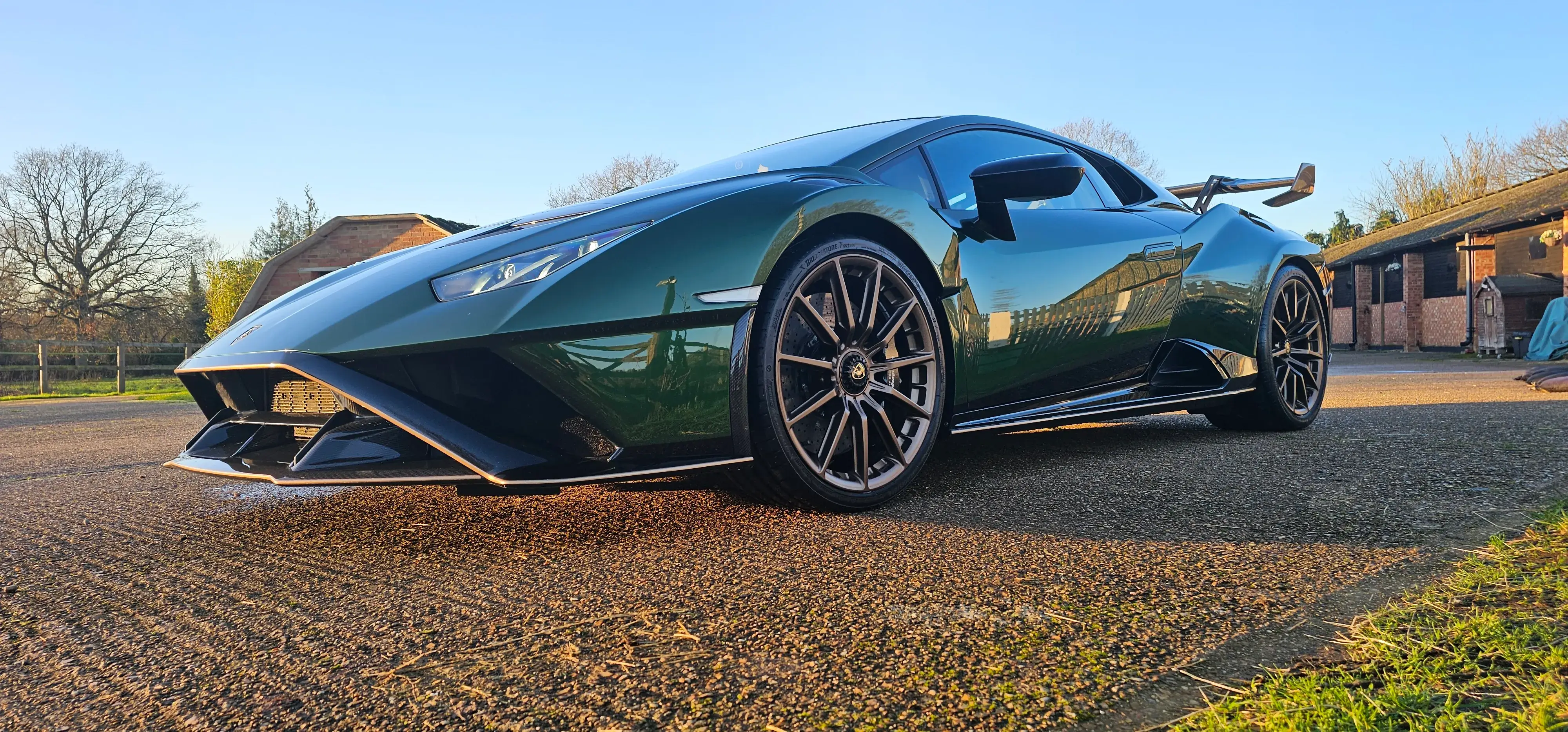 A green sports car parked on the side of the road.